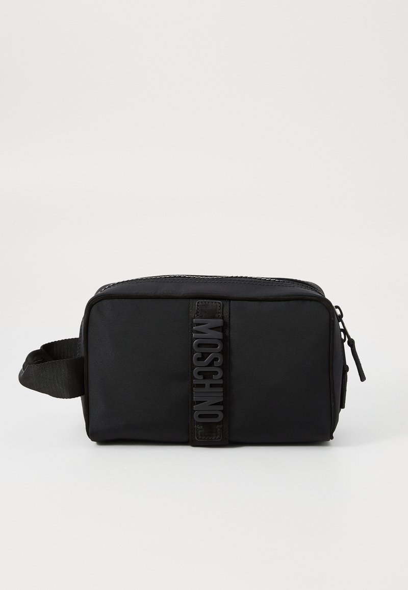 Bolsa de toiletry em nylon preta com uma superfície texturizada, fecho zip, pega lateral e um logotipo em relevo exibido em destaque na frente.