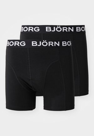 Črni bokserice iz mehkega blaga, z širokim elastičnim pasom, na katerem je v belem napisan "BJÖRN BORG". Gladka tekstura in oprijet dizajn.