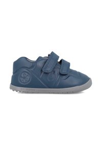 Zapatos infantiles azules hechos de material flexible con un acabado suave. Presentan dos correas de Velcro y una suela de goma gris.