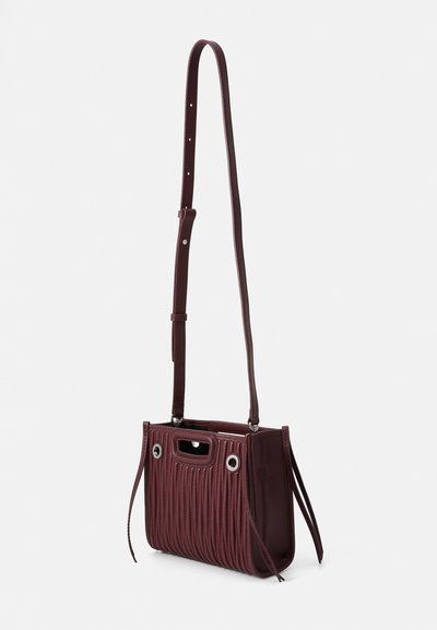 Bordeaux leren handtas met een verticale geribbelde textuur, verstelbare schouderriem, handvatten aan de bovenkant en metalen oogjes aan de zijkanten.