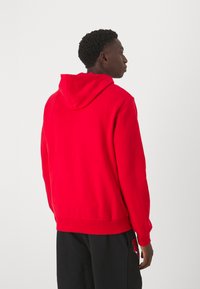 Rote Kapuzenjacke mit lockerer Passform, gerippten Bündchen und Saum, glatter Textur und einer Kängurutasche auf der Vorderseite.