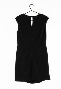 Robe noire sans manches, longueur au genou, avec une fermeture éclair au dos et une petite ouverture en forme de goutte, suspendue à un cintre noir sur fond blanc.