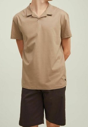 Beige kortærmet polo skjorte med en afslappet krave, lavet af blødt stof. Bæres med mørkebrune shorts, der har et simpelt design uden mønstre.