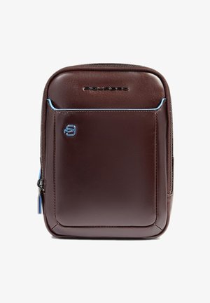 Bruine leren rugzak met een gladde textuur, contrasterende blauwe accenten, een voorvak met rits en een logodetail. Compacte rechthoekige vorm.