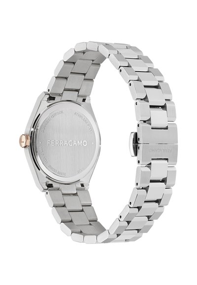 Hõbedane roostevabast terasest kell oktaagonaalse korpusega, mati viimistlusega ja lingitud käevõruga disainiga. Graveeritud tagaküljel on logo "Ferragamo".