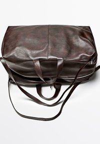 Hnědá kožená taška typu duffle s hladkou texturou, pevnými držadly a zipem. Tvar je obdélníkový, s plochým dnem a zaoblenými hranami.