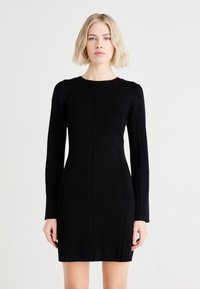 Black long-sleeve dress with a fitted silhouette, made from textured fabric, featuring a round neckline and vertical seam detailing.