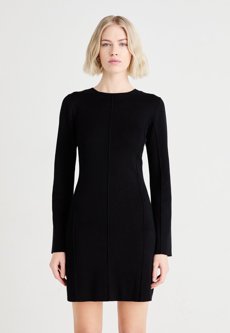 Black long-sleeve dress with a fitted silhouette, made from textured fabric, featuring a round neckline and vertical seam detailing.