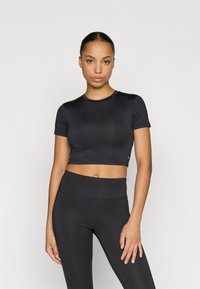 Black cropped athletic top with short sleeves, made from smooth fabric. Paired with matching high-waisted leggings, both have minimal seams.