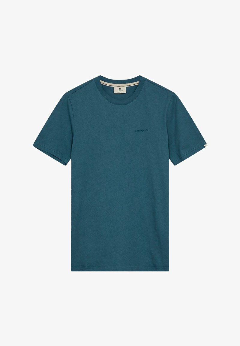 Tealfärgad bomullströja med rund halsringning, korta ärmar, en subtil logo på bröstet och sömnadsdetaljer vid fåll och ärmar.