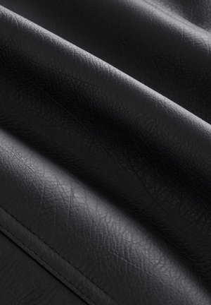 Svart konstläder med en texturerad yta som visar djupa rynkor och veck, vilket framhäver dess flexibla och mjuka karaktär.