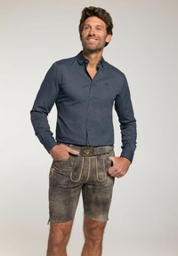 Marine blauwe overhemd met lange mouwen en een button-down kraag, voorzien van een gestructureerd patroon, gecombineerd met grijze shorts met borduursel en lichte accenten.