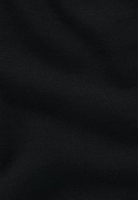Gros plan d’un tissu noir avec une texture finement côtelée et de légères plis, montrant un motif de maille fine et une surface douce.
