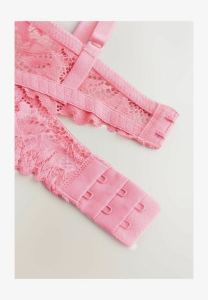 A rózsaszín csipkés melltartópántok fodros széllel, bonyolult mintákkal és puha állítható fémalkatrészekkel rendelkeznek. Az anyag sima és texturált elemeket egyaránt ötvöz.