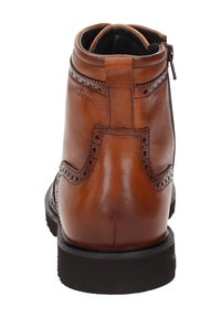 Stivale alla caviglia in pelle marrone con punta tonda, dettagli decorativi brogue e una finitura liscia, dotato di una cerniera laterale per una facile calzata.