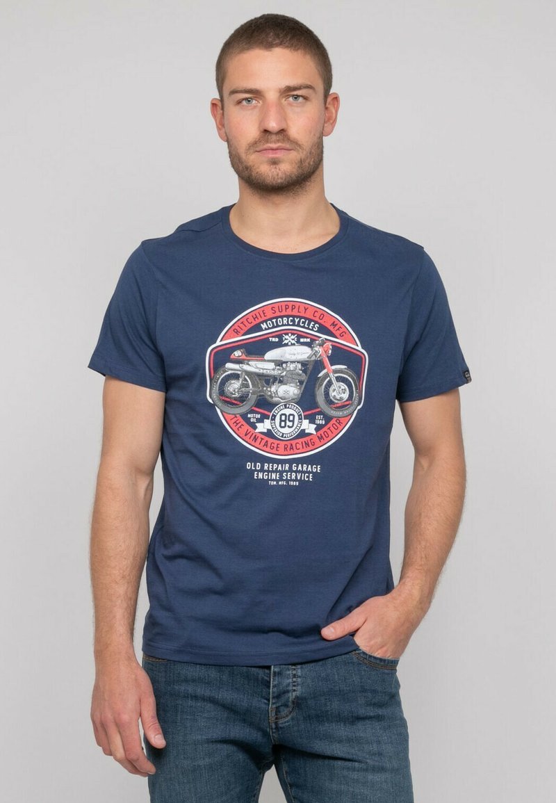 T-shirt bleu marine en coton, avec un graphique de moto vintage en rouge et blanc, col rond et manches courtes.