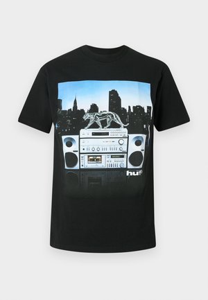 Μαύρο μπλουζάκι με γραφικό ενός boombox και διάφανης πάνθηρας, σε φόντο από την ορίζοντα της πόλης.