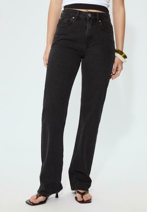 Jeans neri in denim a vita alta con gambe dritta, dotati di chiusura a bottone, tasche frontali e dettagli di cucitura discreta.