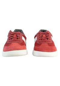 Sneaker rosso in suede con dettagli in rete, accenti laterali bianchi, lacci rotondi e suole in gomma bianca testurizzata. Vista frontale che mostra un design simmetrico.