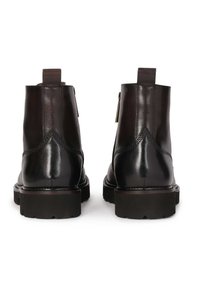 Botas de tobillo de cuero negro con un acabado suave, puntera redondeada, suela de goma resistente y cierre de cremallera accentuado por una etiqueta de tira.