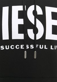 Felpa con cappuccio nera con grande logo bianco "DIESEL" e testo più piccolo "SUCCESSFUL LIVES." Presenta coulisse nere con terminali metallici. Tessuto morbido al tatto.