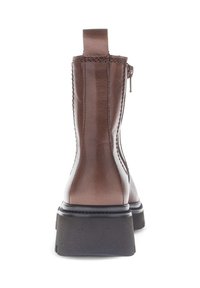 Brown leather ankle boot with a smooth finish, side zipper, and pull tab. Features a solid black rubber sole and textured stitching.
