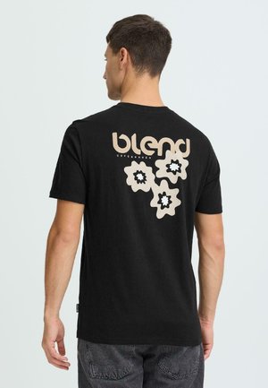 Zwart katoenen T-shirt met korte mouwen, voorzien van een beige bloemenafbeelding en de tekst "blend copenhagen" op de achterkant.