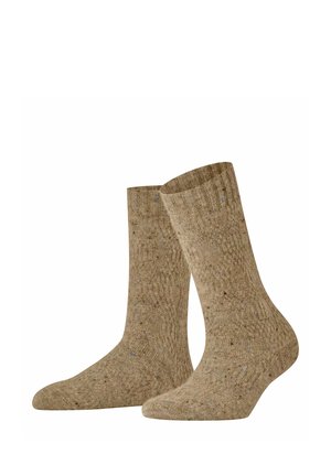 Par midtkalves brune strikkede sokker med et tekstureret mønster og små pletter af mørkere og lysere farver gennem hele stoffet.