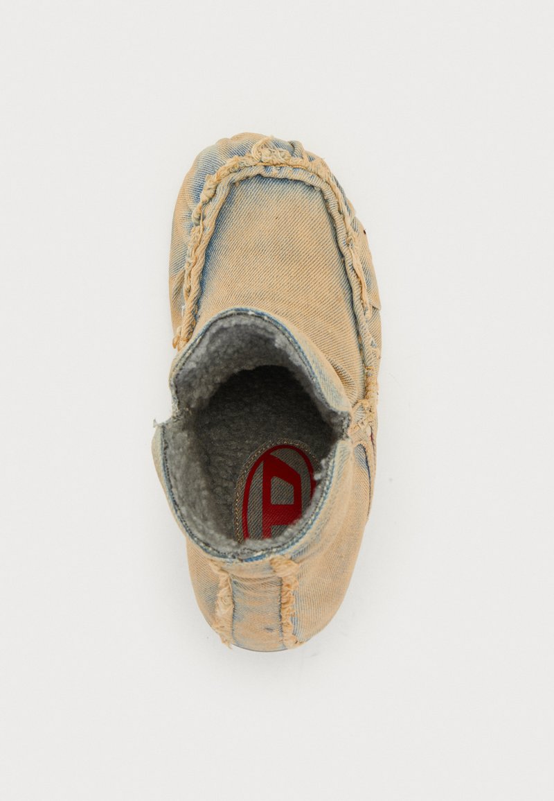 Denim-Schlappen mit einem weichen grauen Innenfutter, genähten Details und runder Zehenpartie. Merkmale ein rotes Logo auf der Innensohle und ausgefranste Kanten.