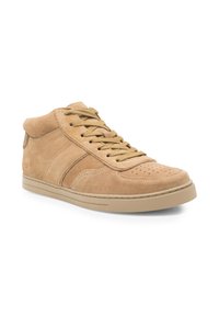 Zapatilla deportiva de ante marrón claro de media altura con puntera perforada, cuello acolchado, cordones beige y suela de goma beige, en ángulo para mostrar el lado exterior.