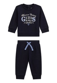 Marineblaue Sweatshirt mit aufgedrucktem Logo und Rundhalsausschnitt, kombiniert mit marineblauen Jogginghosen, die einen elastischen Bund und einen himmelblauen Kordelzug haben.