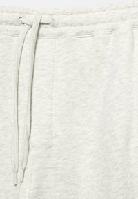 Light gray jogger pants made of soft, textured fabric with an elastic waistband, drawstring, and side pockets.