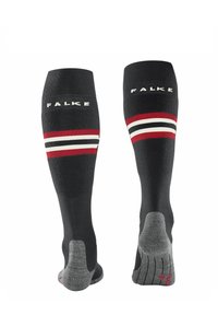 Calze nere fino al ginocchio con strisce rosse, bianche e nere; presentano il logo "FALKE" in alto e grip testurizzati sulla suola.