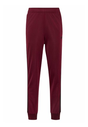 Pantalones deportivos de corte slim en color marrón granate con cintura y puños elásticos, que cuentan con franjas laterales negras y un pequeño logo negro en la parte superior del muslo.