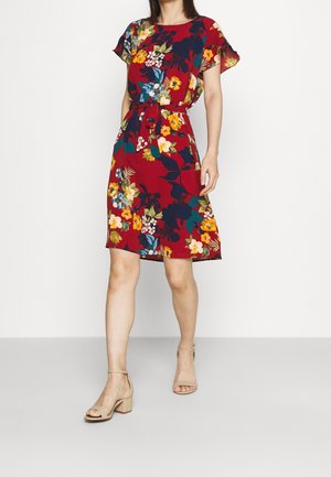 Robe fleurie rouge à manches courtes, taille ceinturée, et ourlet à hauteur du genou. Présente différents coloris dans des motifs floraux sur un fond uni.