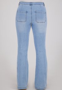 Lichtblauwe flare jeans met hoge taille, voorzien van twee achterzakken en een gladde, licht vervaagde denimstructuur.