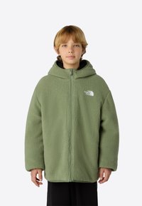 Zöld polár dzseki cipzárral és kapucnival. Puha, texturált anyagból készült, és diszkrét fehér logó található a bal mellrészen.