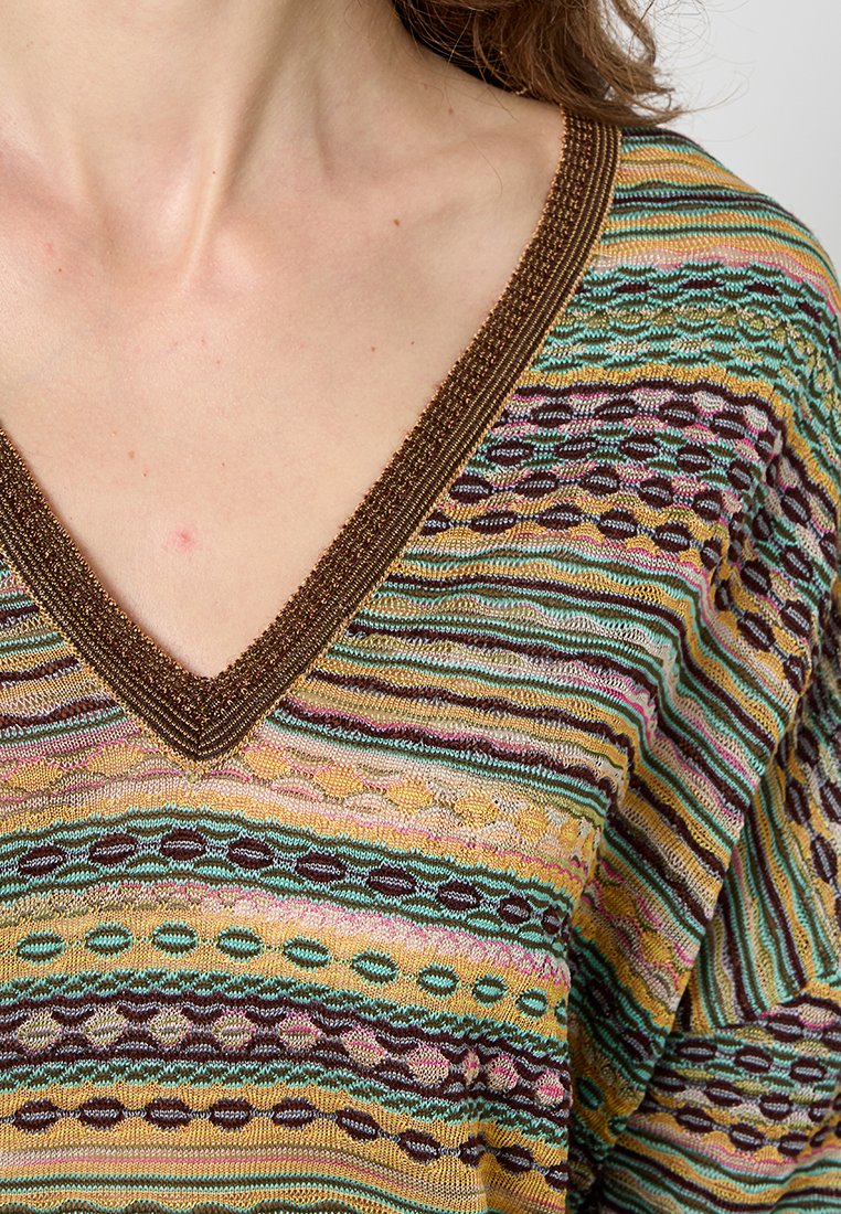 Mehrfarbiger Strickoberteil mit V-Ausschnitt und kunstvollen Mustern in Grün, Gelb, Pink und Braun, verziert mit metallischen Akzenten entlang des Ausschnitts.