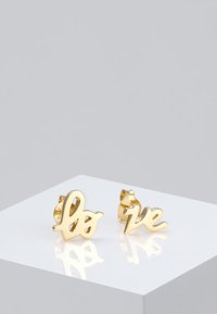 Goldene Ohrringe in Form des Wortes "Liebe" mit einer geschwungenen Schriftart, ausgestattet mit glatter Textur und polierter Oberfläche.
