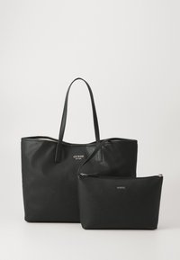 Svart läder tote-väska med två långa handtag, med en subtil textur och präglad "GUESS"-logotyp. Inkluderar en mindre matchande påse.