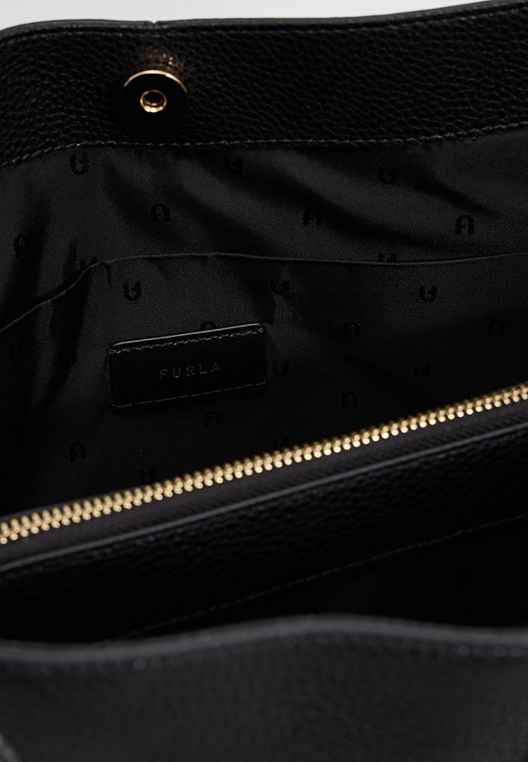 Wnętrze czarnej skórzanej torebki z złotym zamkiem, charakteryzujące się gładką teksturą oraz czarną podszewką z tłoczonym wzorem logo 'Furla'.