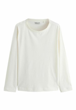 Pikkade varrukatega, ümberkaela särk pehmest valgest puuvillast. Omab lihtsat disaini sirge alumise serva ja mansettidega, ilma nähtavate mustrite või aksessuaarideta.