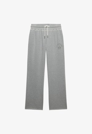 Jasnoszare spodnie dresowe o szerokich nogawkach, z elastycznym pasem, białym sznurkiem i subtelnym logo na górnej części lewego uda.