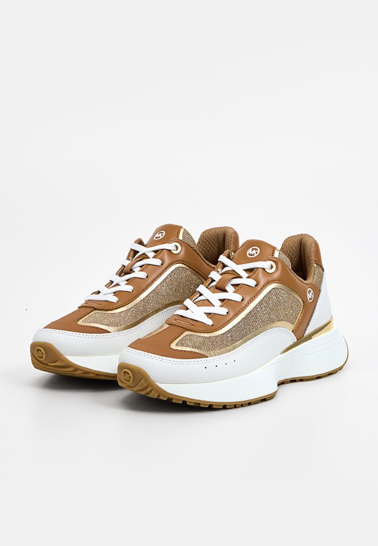 Chaussures de sport marron et blanches avec un dessus texturé, présentant des accents métalliques, des lacets blancs et une semelle blanche épaisse.