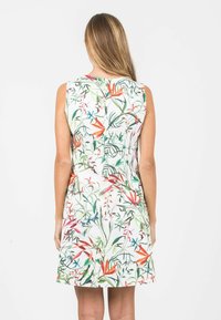Sleeveless dress in white with a colorful floral pattern featuring green leaves and orange, pink, and blue flowers; knee-length design.