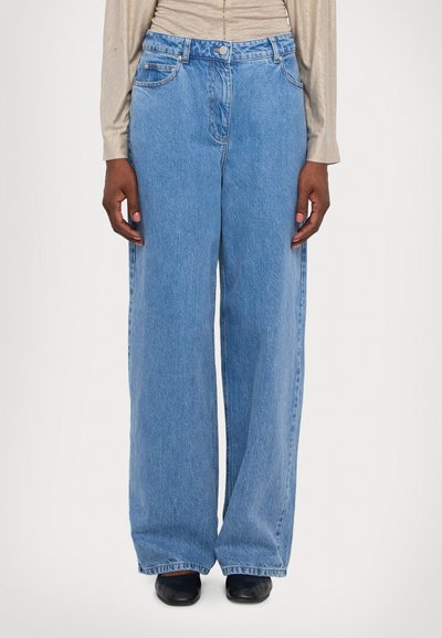 Jeans de tiro ancho de color azul claro, confeccionados en denim. Presentan un diseño clásico de cinco bolsillos y un cierre de botón en la cintura.