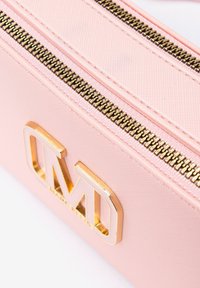Borsa in tessuto rosa con una texture liscia, caratterizzata da hardware dorato e un logo. Due cerniere metalliche percorrono il bordo superiore.