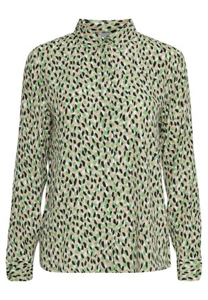 Camisa de manga larga en tejido ligero con un patrón abstracto en verde, negro y blanco sobre un fondo beige; presenta un collar y puños con botones.