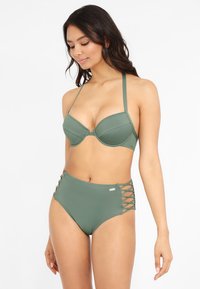 Bikini taille haute en vert olive, comportant un haut à bonnets moulés avec des bretelles ajustables et des détails croisés sur les côtés du bas.
