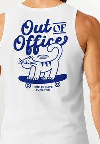 Weißes Tanktop mit blauer Grafik und dem textlichen Element "Out of Office" über einem Cartoon-Kater auf einem Skateboard, begleitet von dem Satz "Zeit Spaß zu haben."